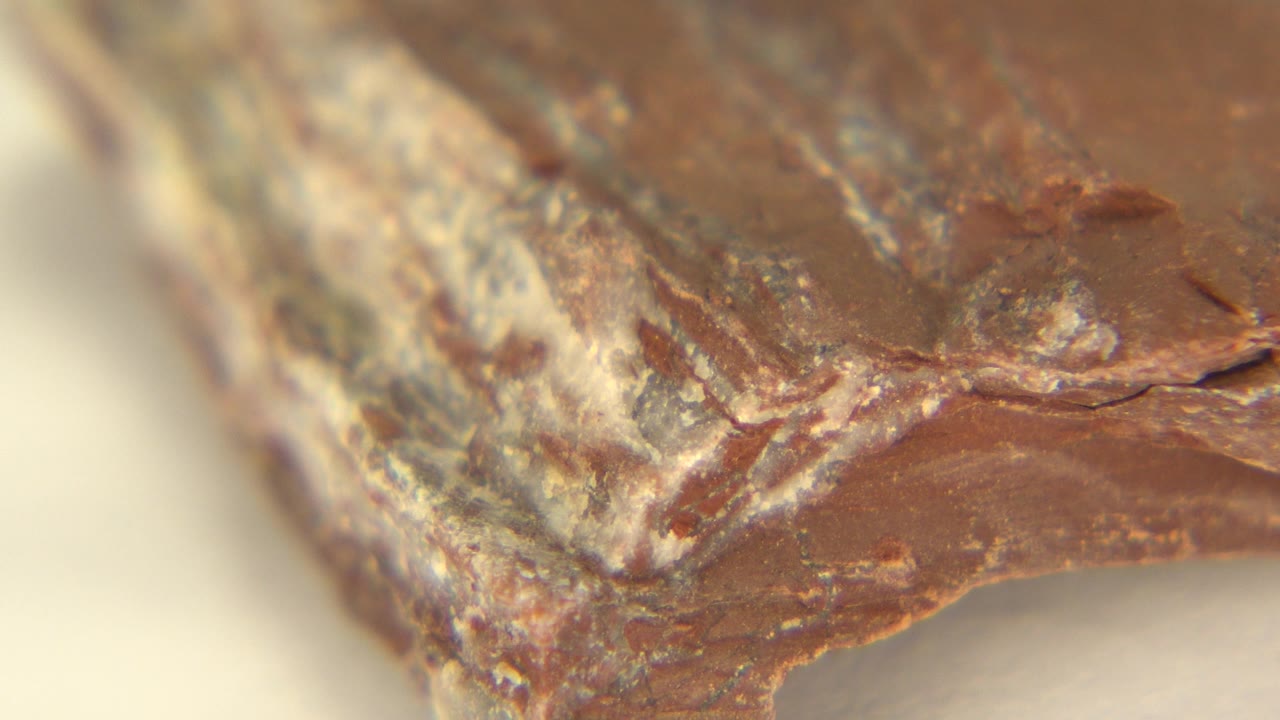 Angled close-up of the rock corner with white and reddish layers.
