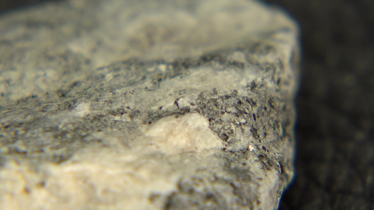 Close stone corner with gray speckled texture and cream highlight