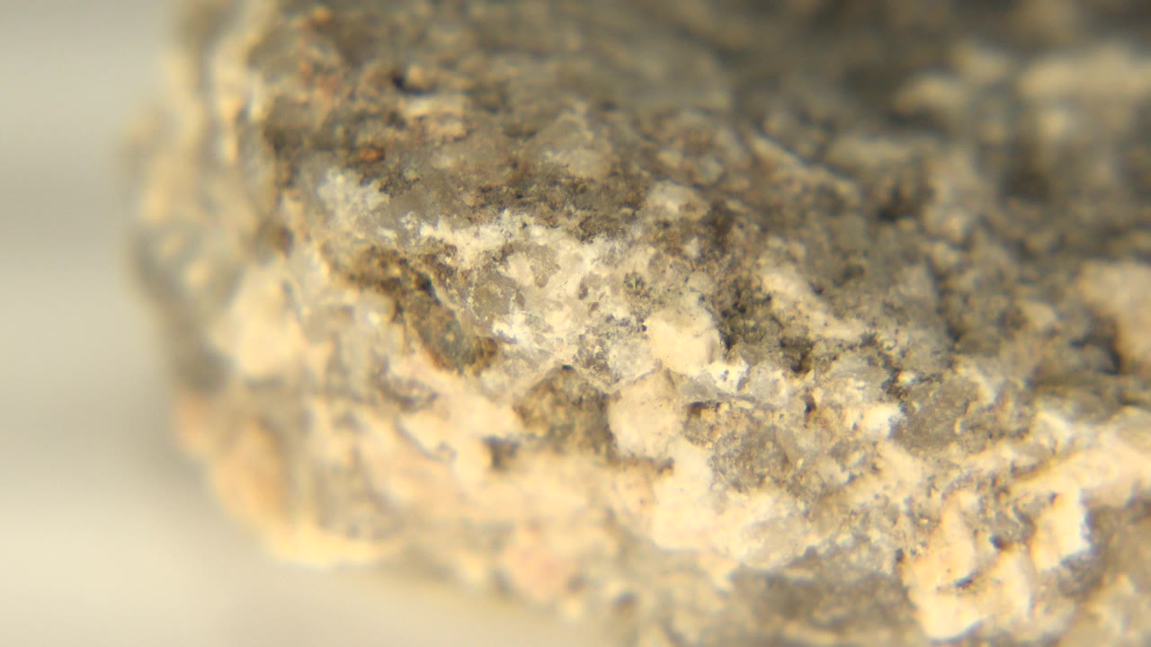 At 0:00, a rough yellow-gray rock fills the foreground on a white floor in Westminster, Colorado, with no visible people in the frame.