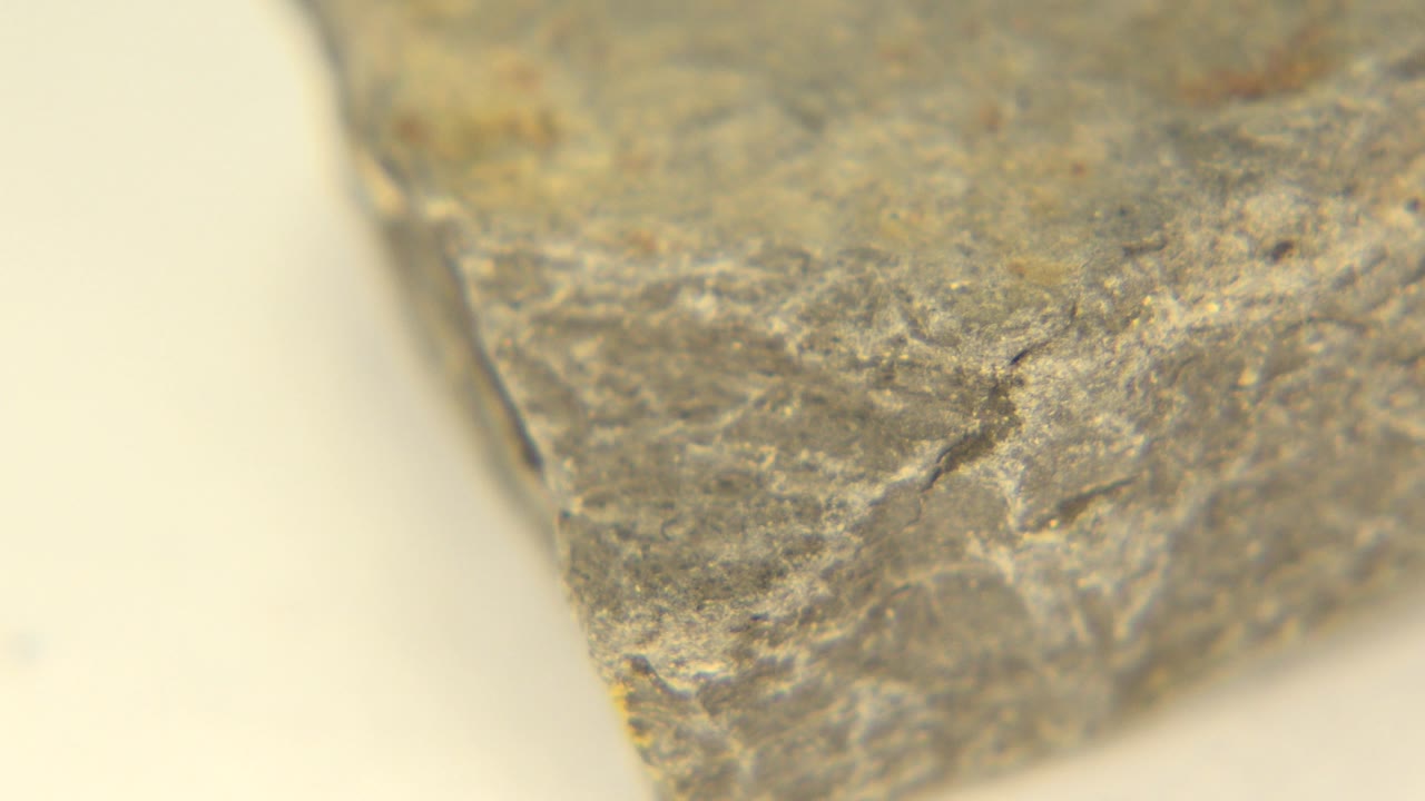 Angled edge of a brown-gray rock on a table.