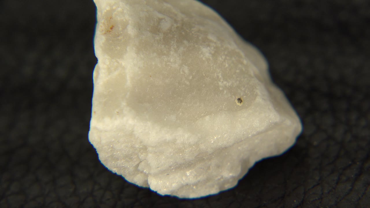 Rotated white rock with pointed upper edge on black.