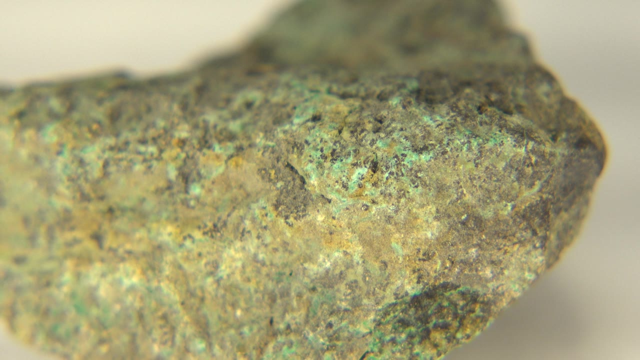 Rough rock edge with green mineral coloring in shallow focus.
