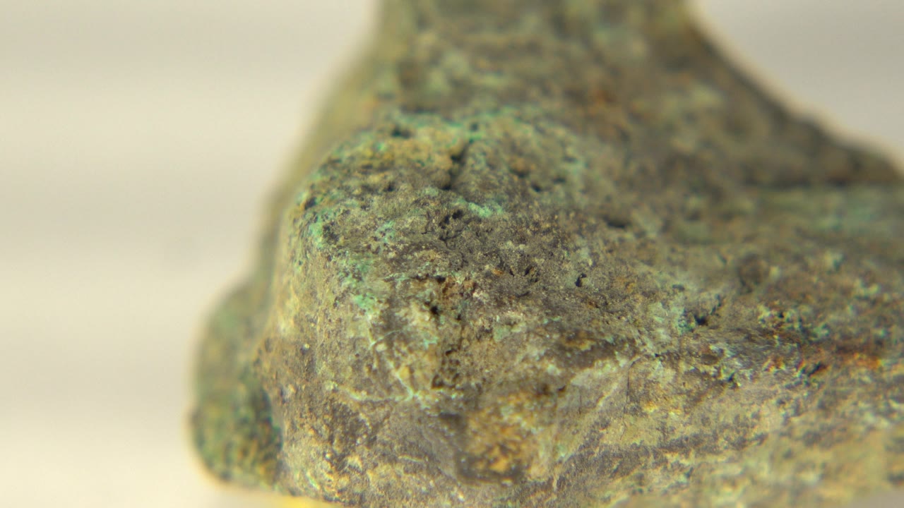 Close detail of a green rock edge against a pale background