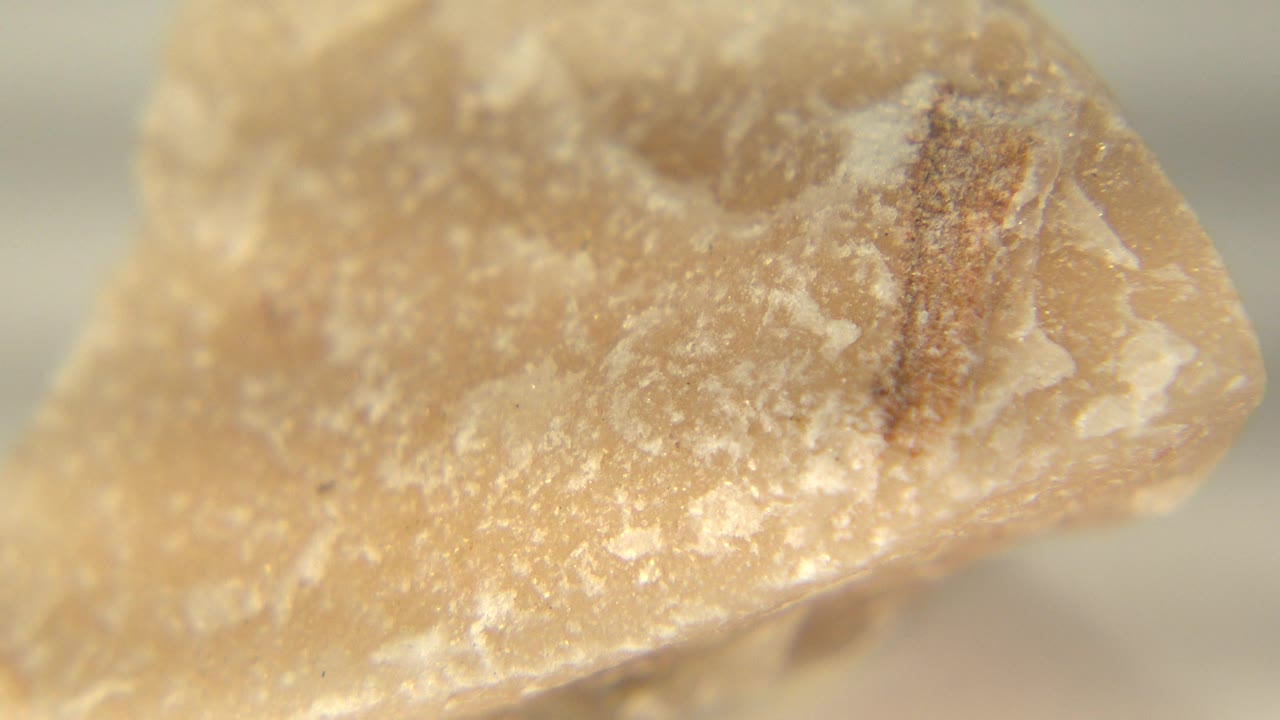 At 0:01, the Westminster rock remains in close focus, showing a dark brown streak across the upper surface, pale crystalline marks, and no visible people.
