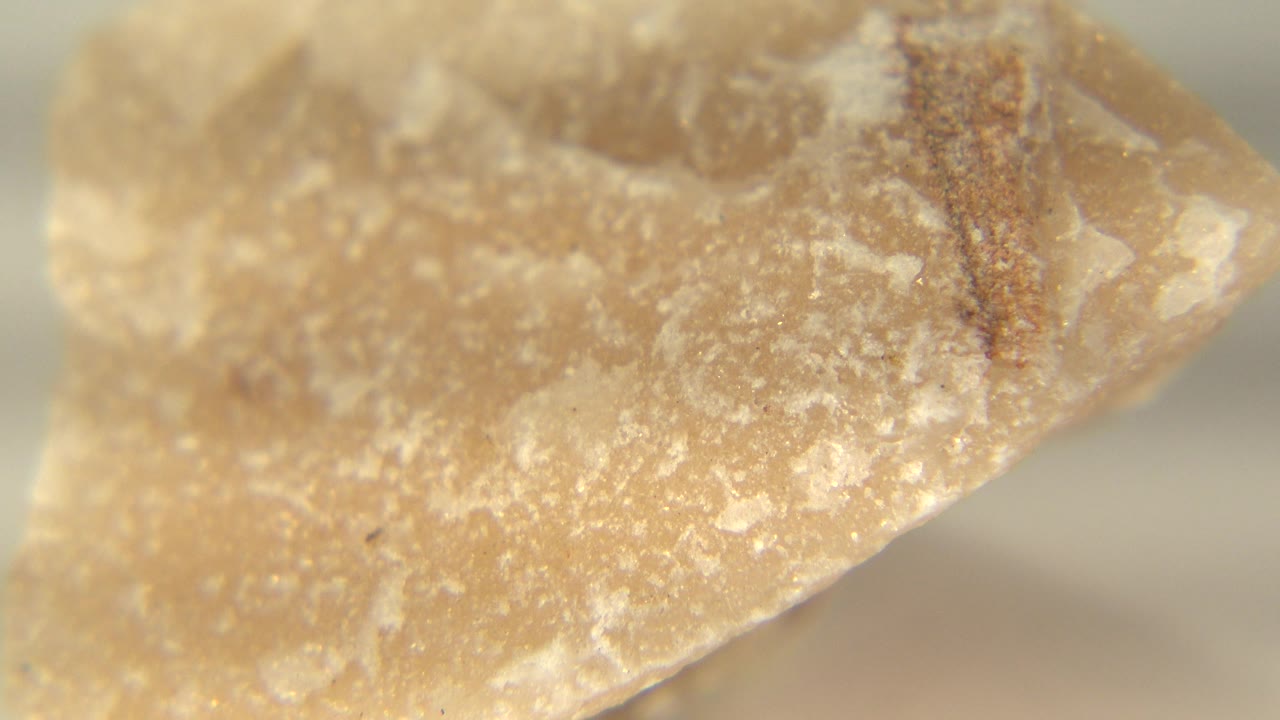 Pointed edge of a yellow tan rock against a soft background.