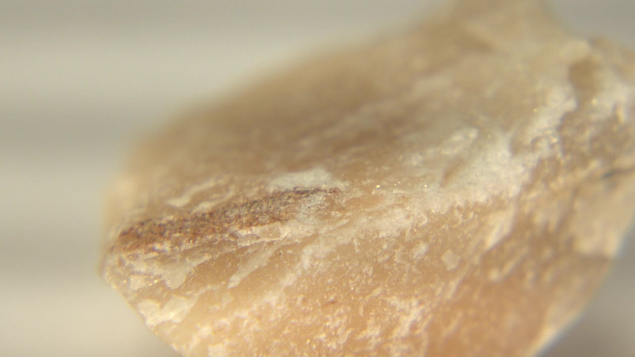 Close frame of a pale pink beige rock in Westminster, Colorado, showing a rough edge and cloudy crystalline texture with no visible people.