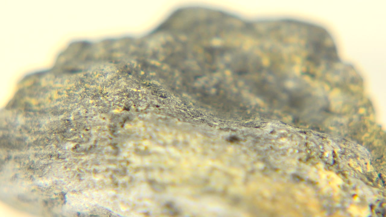 Extreme close-up of a gold-gray rough rock surface in Westminster, Colorado, with shallow focus and no visible people.