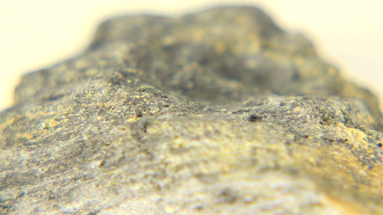 Macro view of a rough stone with warm gold highlights.