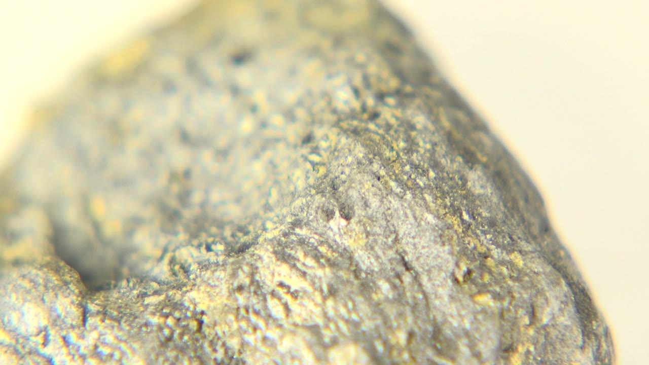 Close-up of the rock angled across the frame with yellow and gray surface detail.