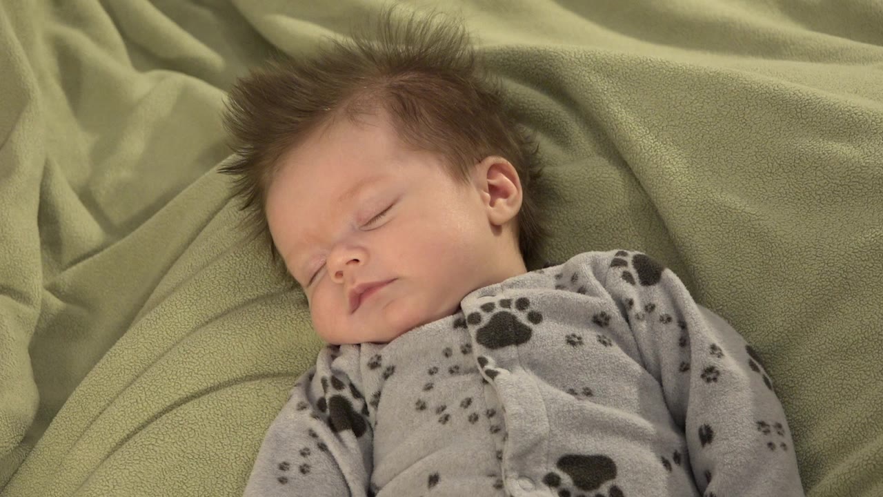 Sleeping baby on a green blanket