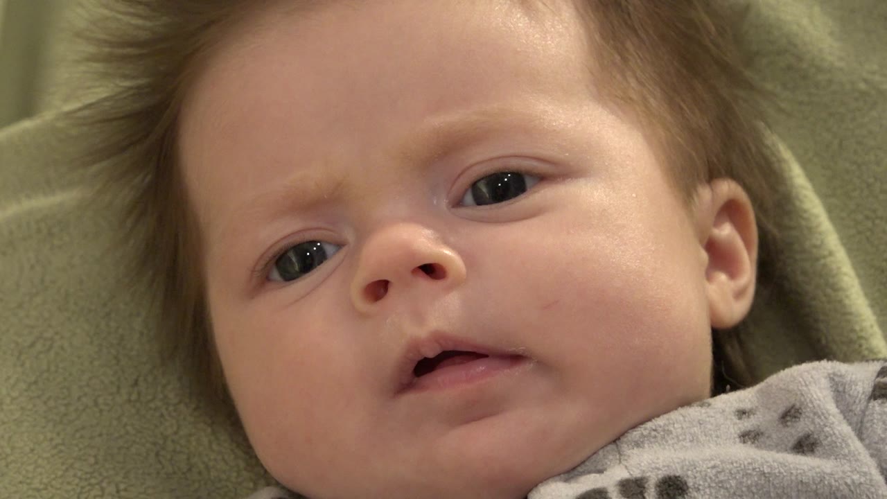 Baby looking toward the camera with a furrowed brow.