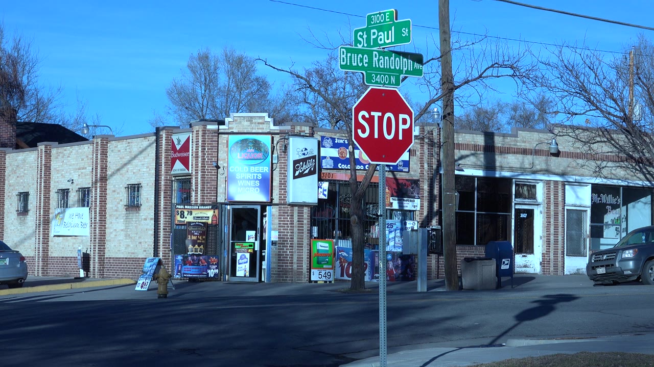 Denver street corner holds on the same brick storefronts, with St Paul Street and Bruce Randolph Avenue signs above a stop sign and no visible people.