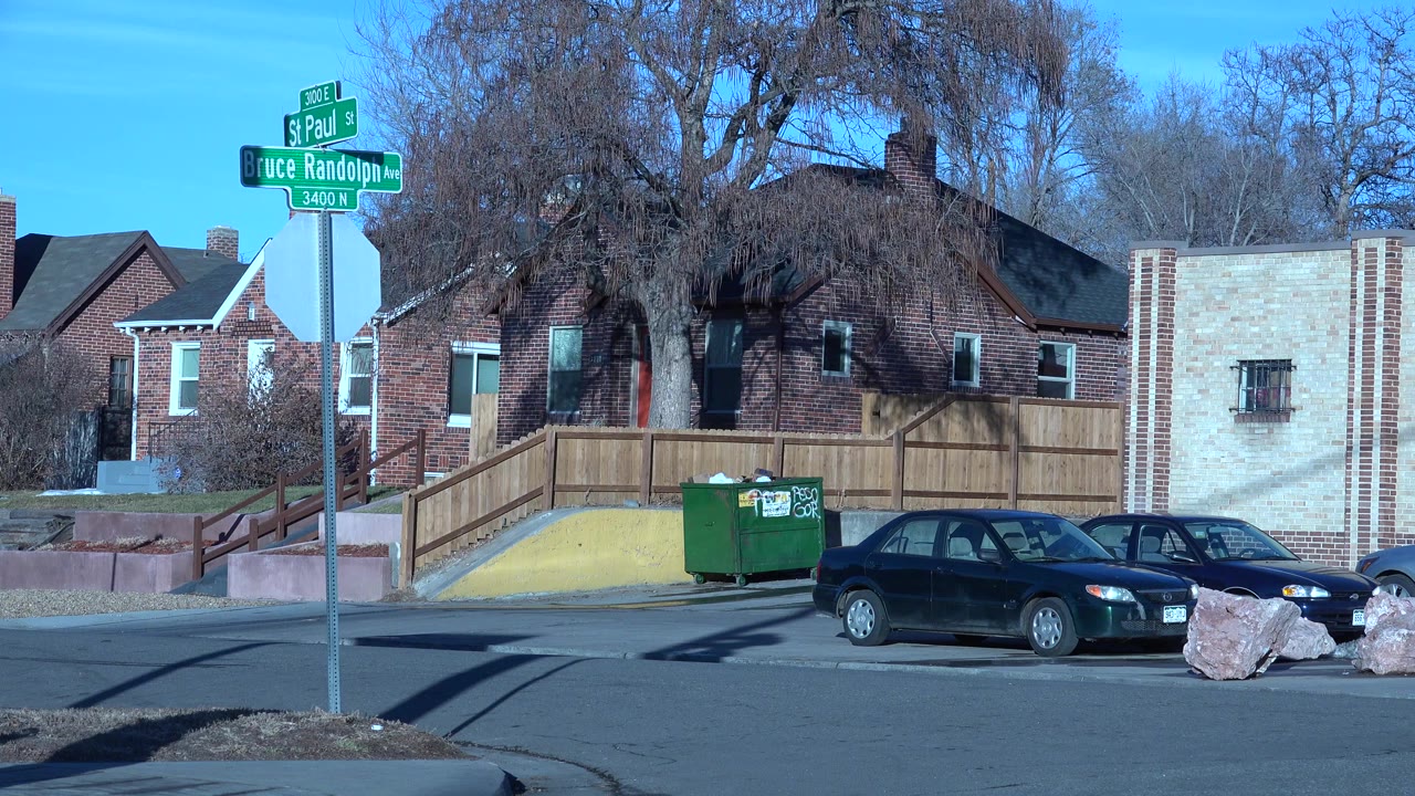 Street corner with parked cars outside brick buildings