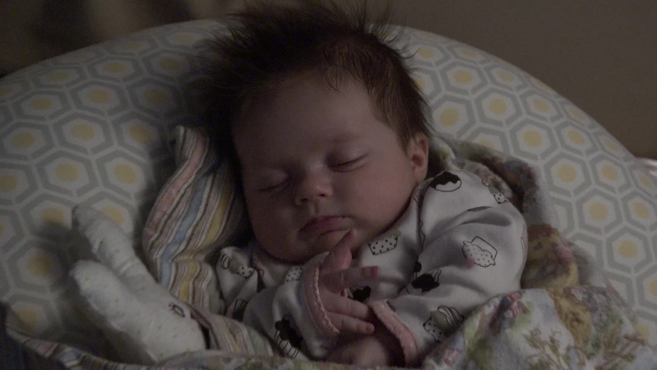 Closer view of a sleeping baby on pillows.