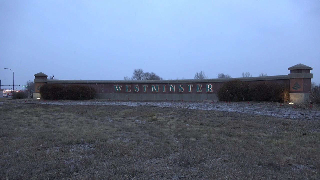 Westminster sign wall behind frosty grass at dusk
