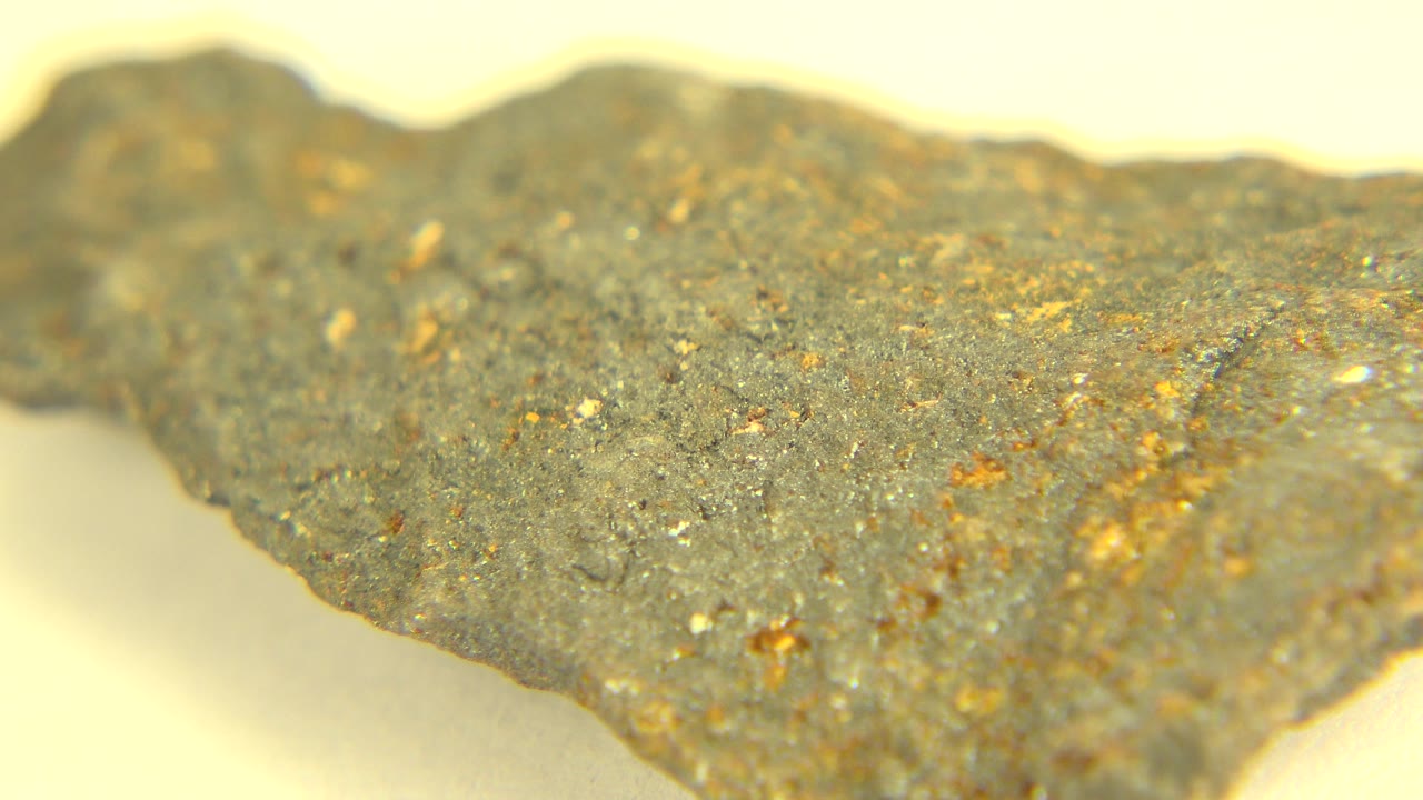 Uneven gray rock edge on a pale tabletop background.