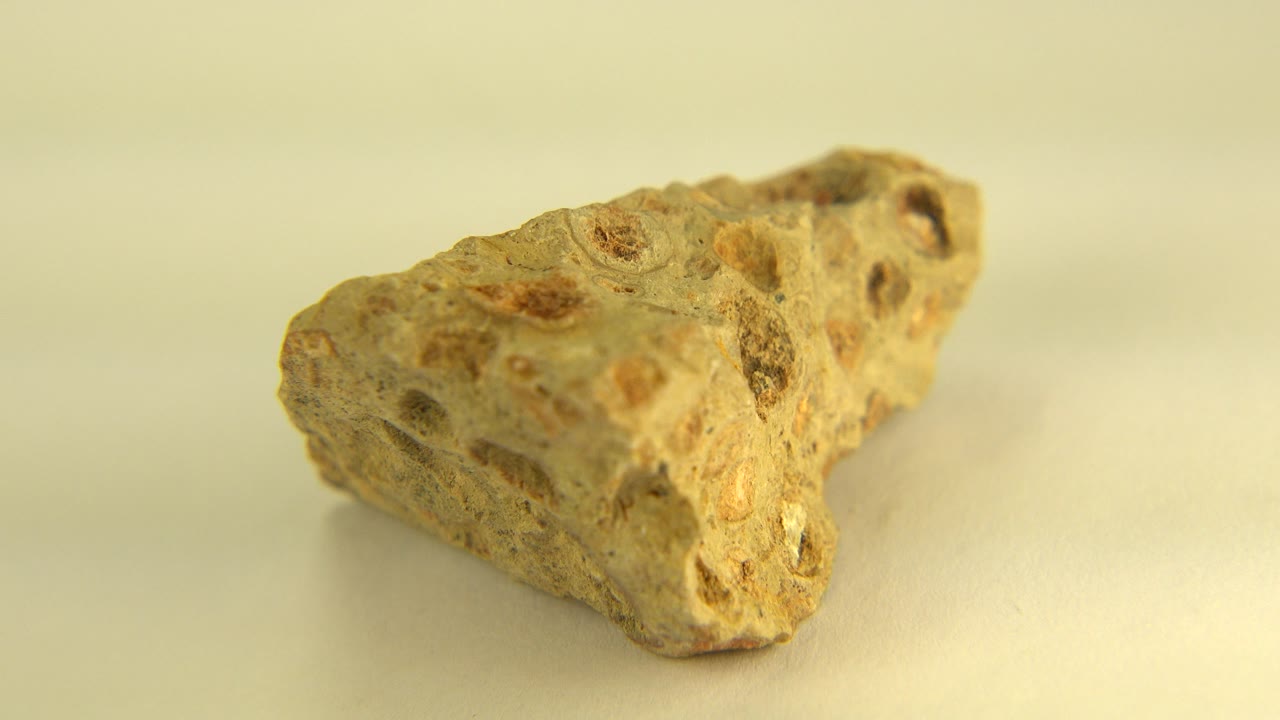 A low close-up in Westminster, Colorado shows the same yellow stone with shallow holes along the front edge and no visible people.