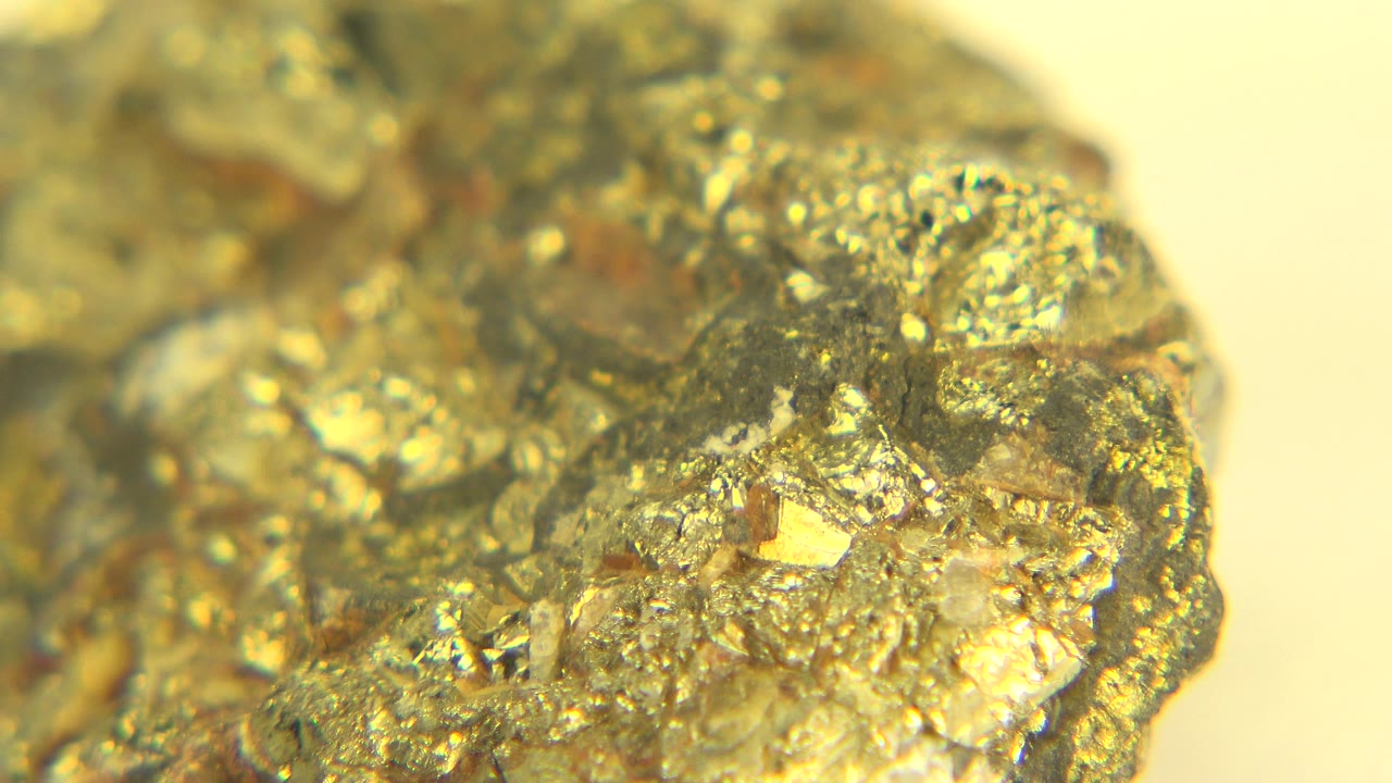 Close-up of a glittering gold and gray rock in Westminster, Colorado, with a bright pale background and no visible people.