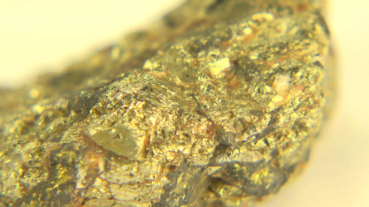 Macro view of a gold and amber rough stone from the Westminster, Colorado 2015 clip, with bright reflective facets and no visible people.