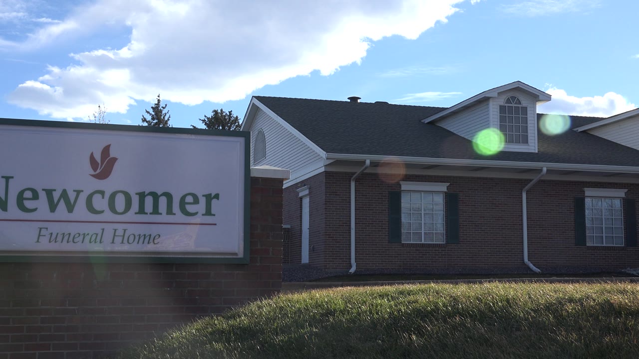 Partial funeral home sign at frame edge with brick building behind it.