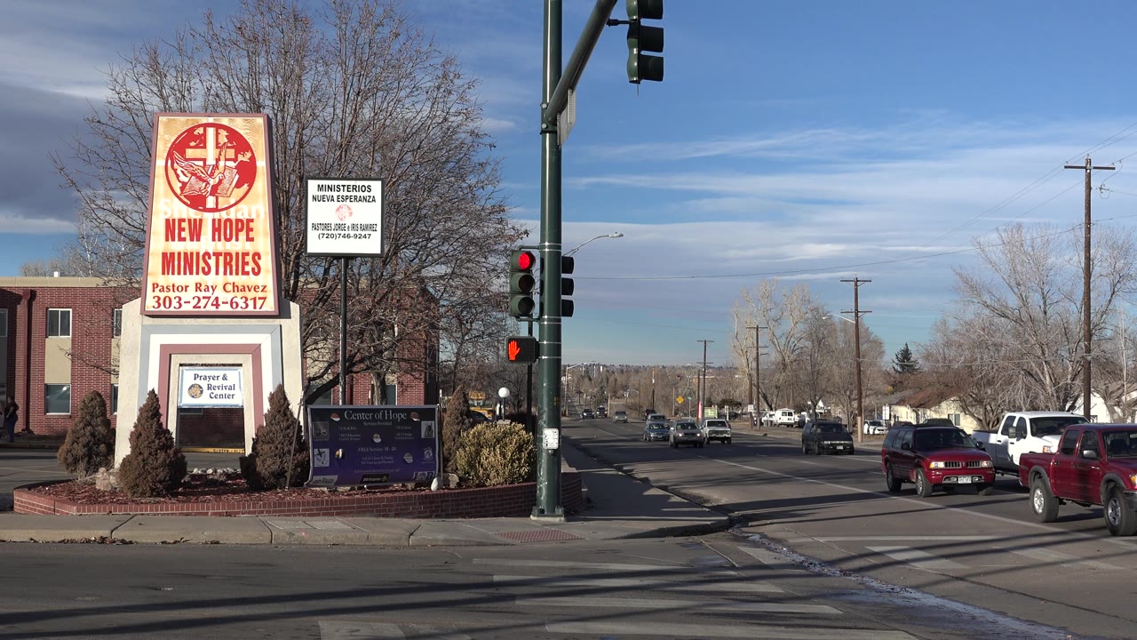 New Hope Ministries sign with a red pickup and white truck near the intersection.
