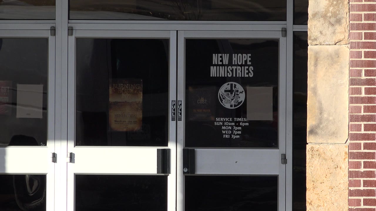 Glass storefront doors with New Hope Ministries signage.