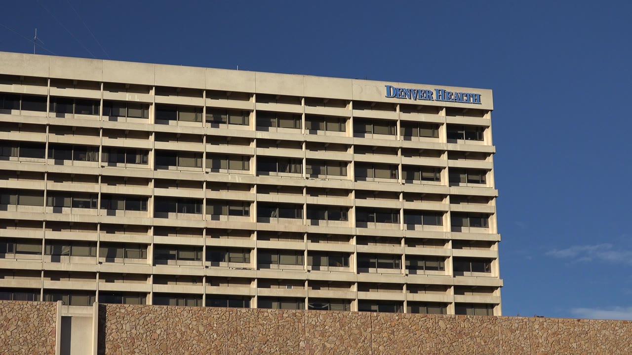 Upper floors of a tan building beneath blue sky