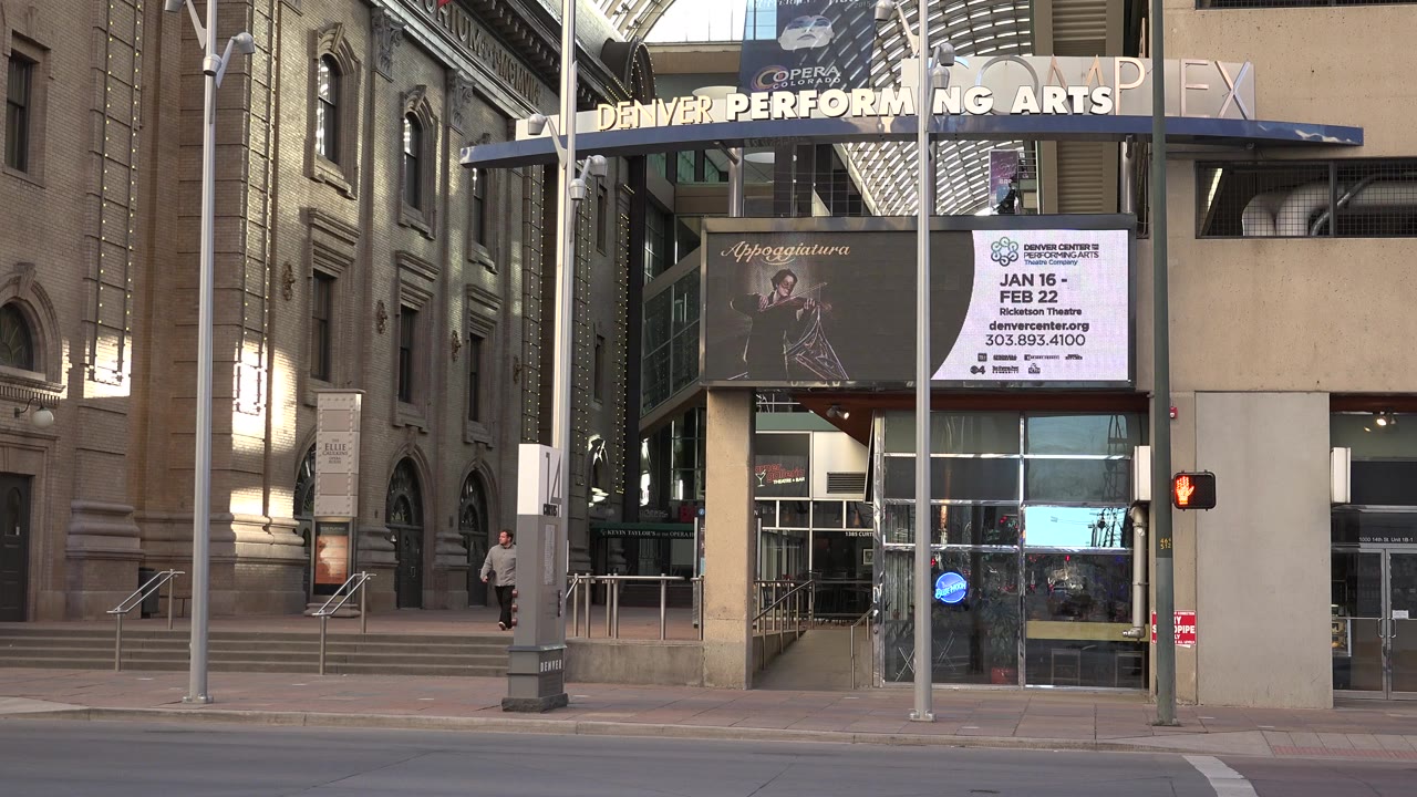 Performing arts entrance with a pedestrian on the sidewalk