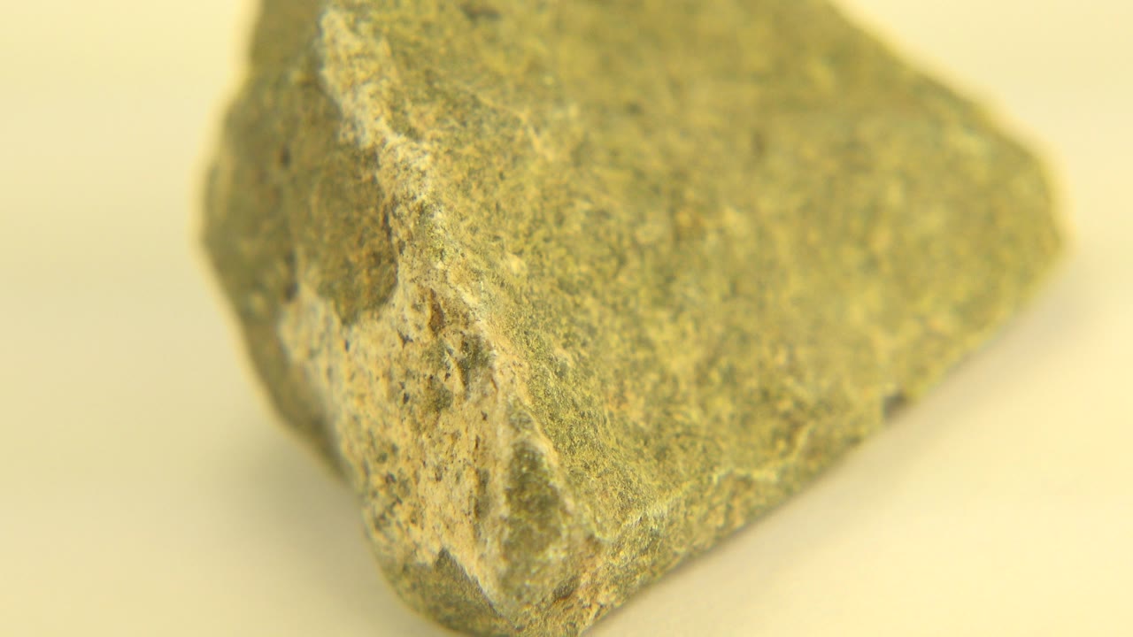 Yellowish rough rock on a pale warm background.