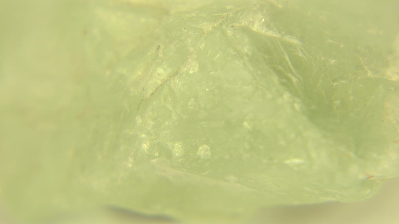 Close view of the gemstone's central facets in Westminster, Colorado, with reflected light across a cloudy green surface and no visible people.