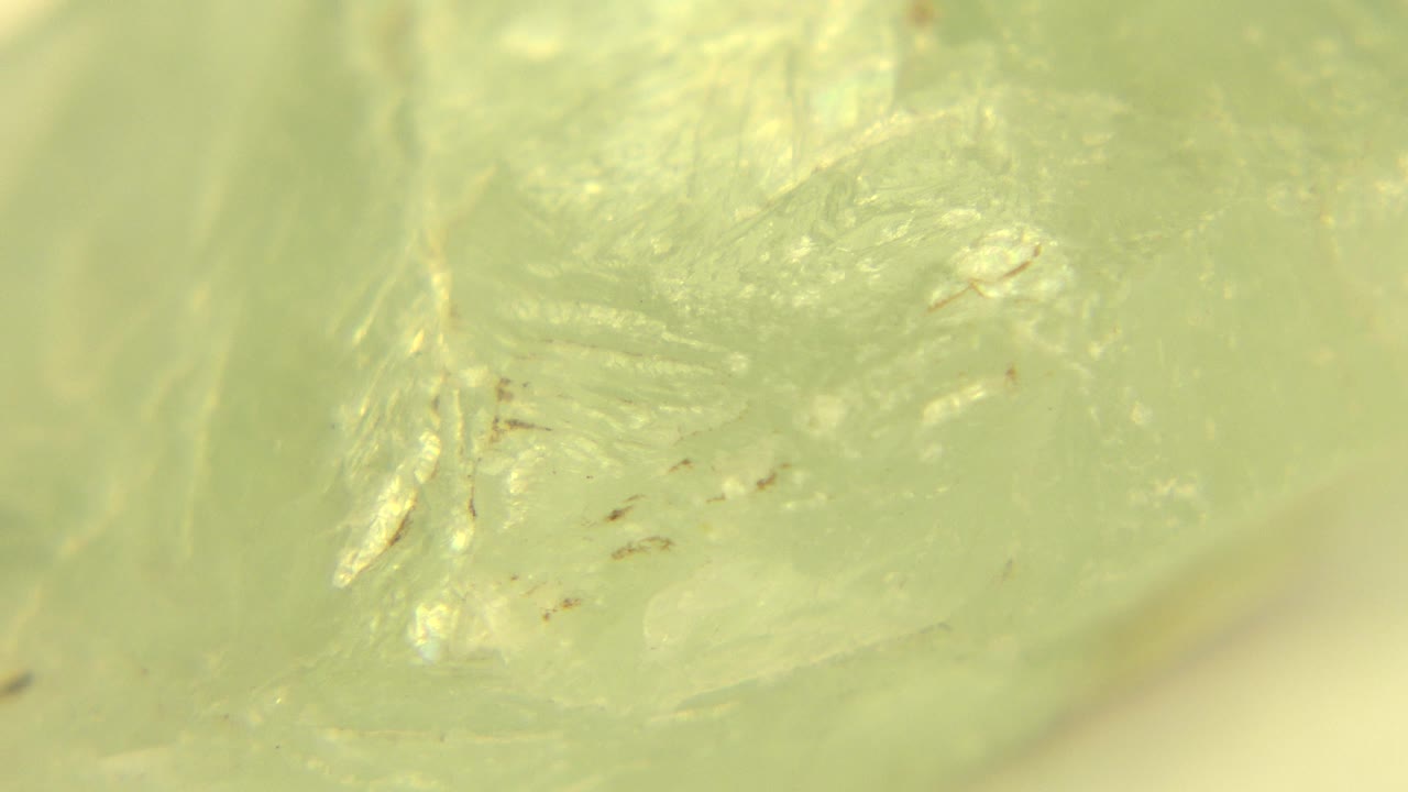 Close view of the greenish white rock in Westminster, Colorado, with several tiny dark specks near the center and no visible people.