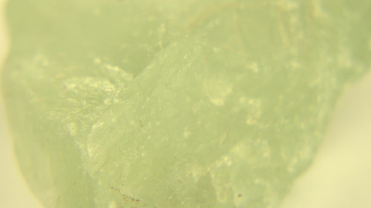 A pale green translucent gemstone fills the first frame in Westminster, Colorado, with cloudy internal texture and no visible people.