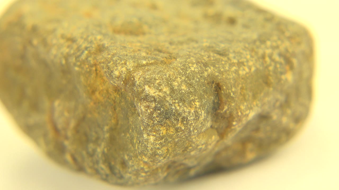 A rough mottled rock-like object fills the frame in a Westminster, Colorado 2015 clip, with tan and gray surface flecks and no visible people.