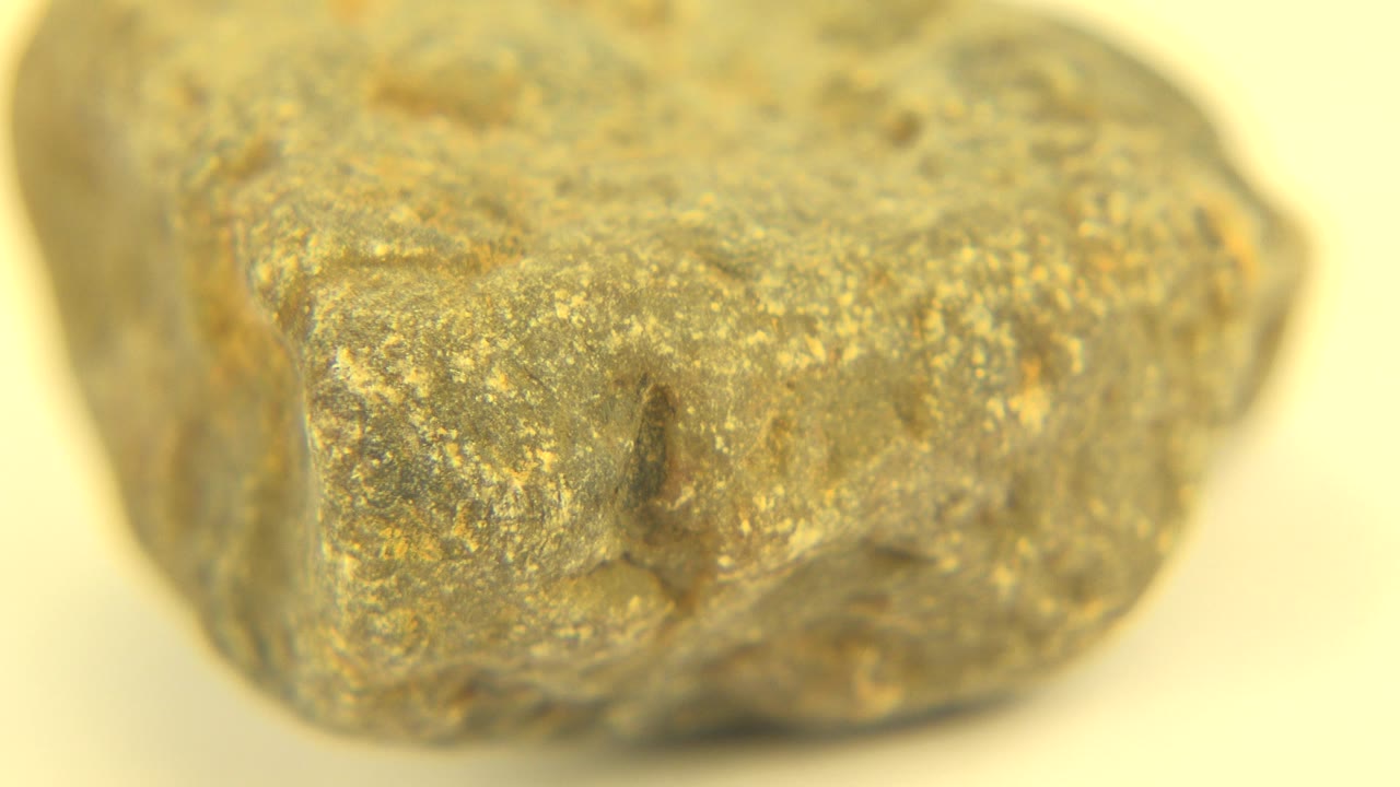 Angular side of a rough tan-gray object in close-up.