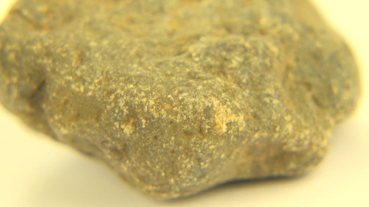 Third frame keeps the rock large in view, showing a rounded upper surface, darker side crease, golden dusting, and no visible people.