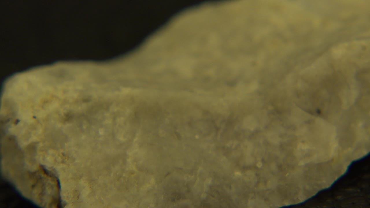 Rotating pale rock with a long rough side visible.