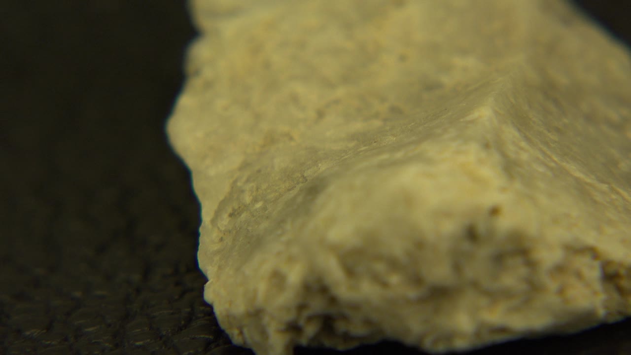 Flat rock angled across a dark display surface