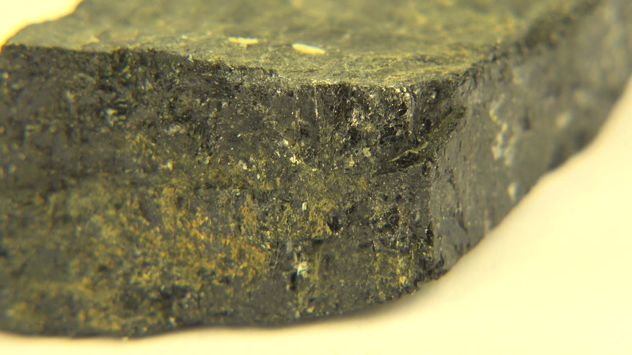 Dark rock surface with a rough side edge in close focus.