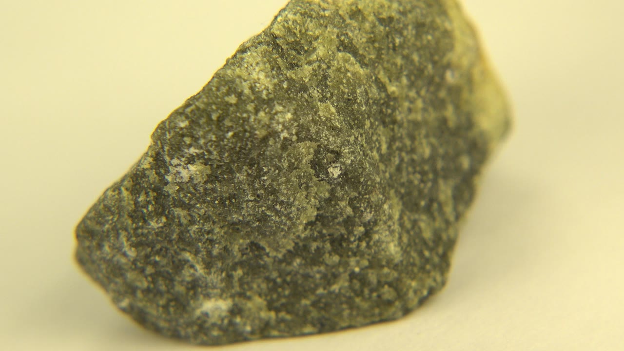 Dark gray and whitish rock shown close up on a pale surface in Westminster, Colorado, with its left side prominent and no visible people.