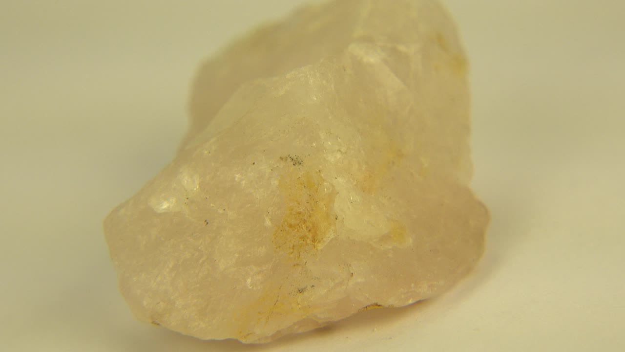 Close view of a pale yellow translucent stone on a light surface in Westminster, Colorado, with warm soft focus and no visible people.