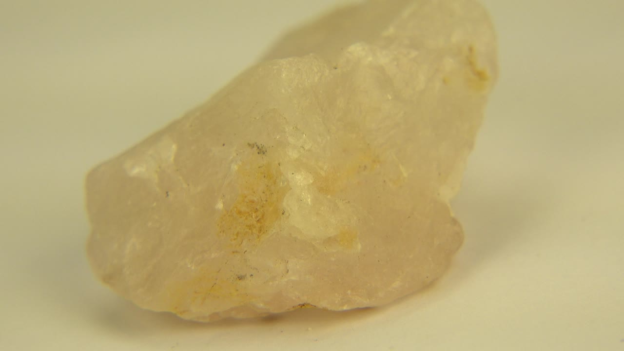 Yellowish stone angled on a plain surface