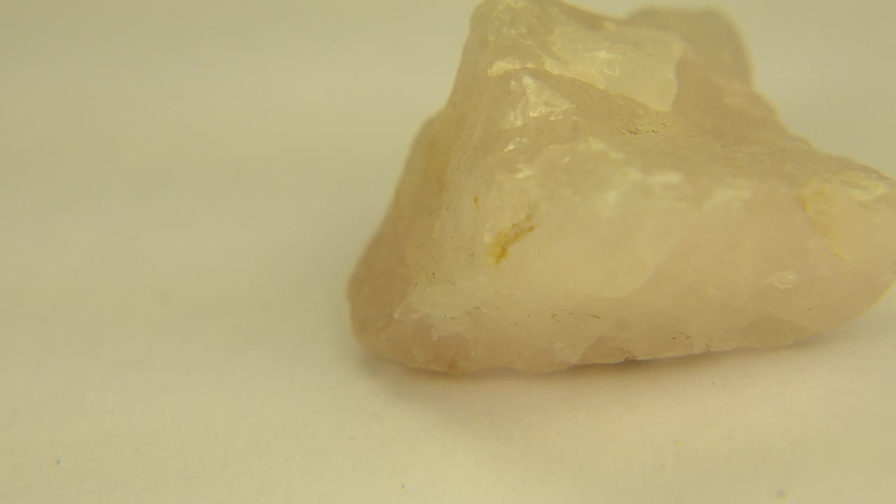The pale rock appears slightly rotated on the white floor in Westminster, Colorado, with cloudy internal texture and a small tan vein visible, and no visible people.