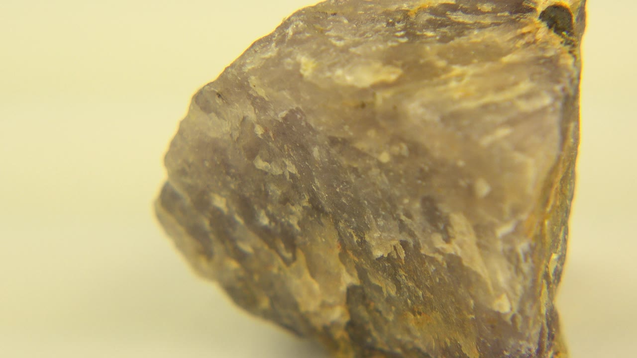 At 0:01, the stone remains centered in Westminster, Colorado, showing layered gray and tan mineral texture across a broad angled face, no visible people.