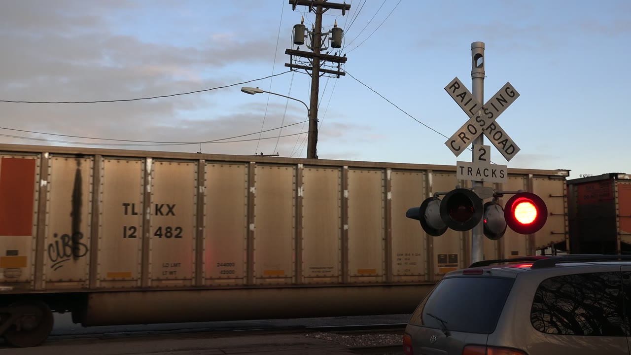Freight train passing a railroad crossing signal with red light on