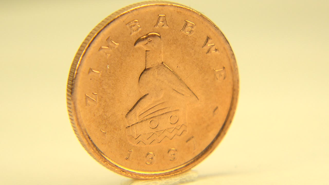 A similar face-on coin view holds the bird emblem and worn lettering near center frame in the Westminster, Colorado footage, with no visible people.