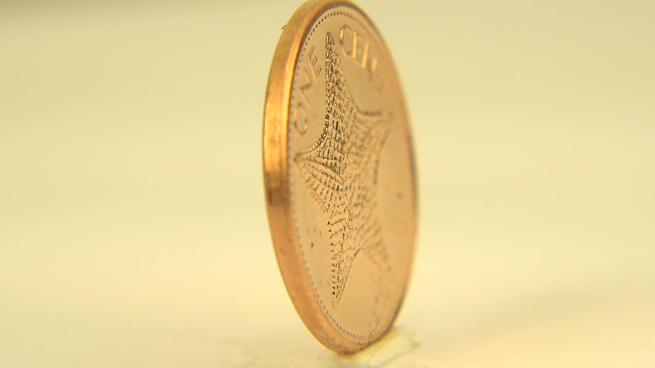 Angled Bahamas one-cent coin with starfish detail partly visible.