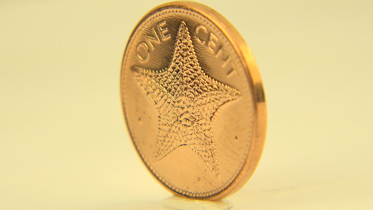 One centavo coin upright with star side facing camera.