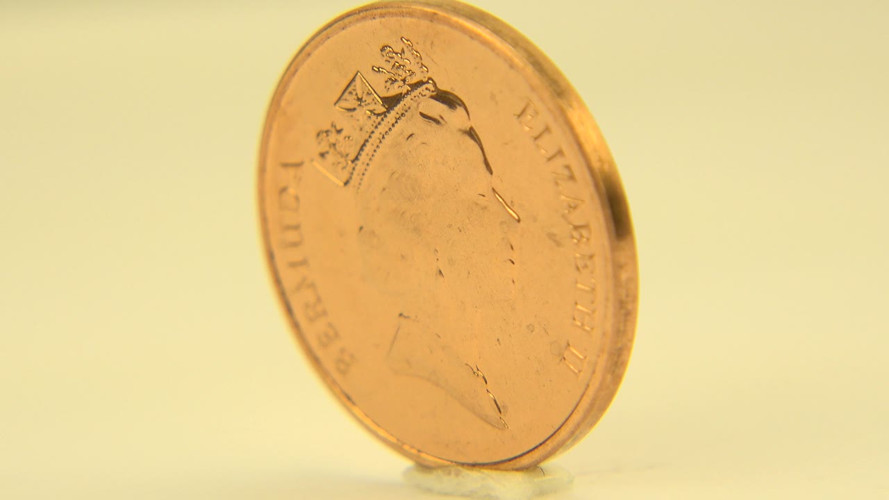 Close-up of the Bermuda penny in Westminster, Colorado, with the portrait side facing the camera more squarely and warm highlights along the rim, with no visible people.