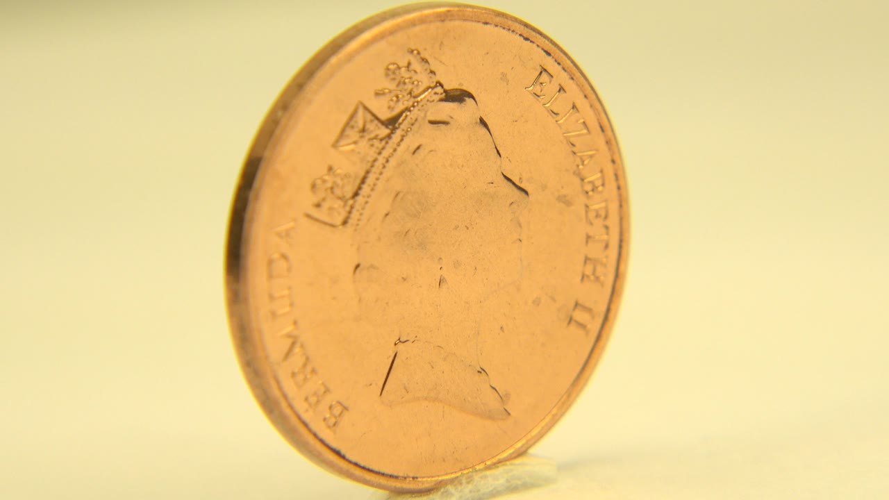 The Elizabeth II coin remains upright in a tight Westminster, Colorado close-up, with warm reflections along the rim and no visible people.