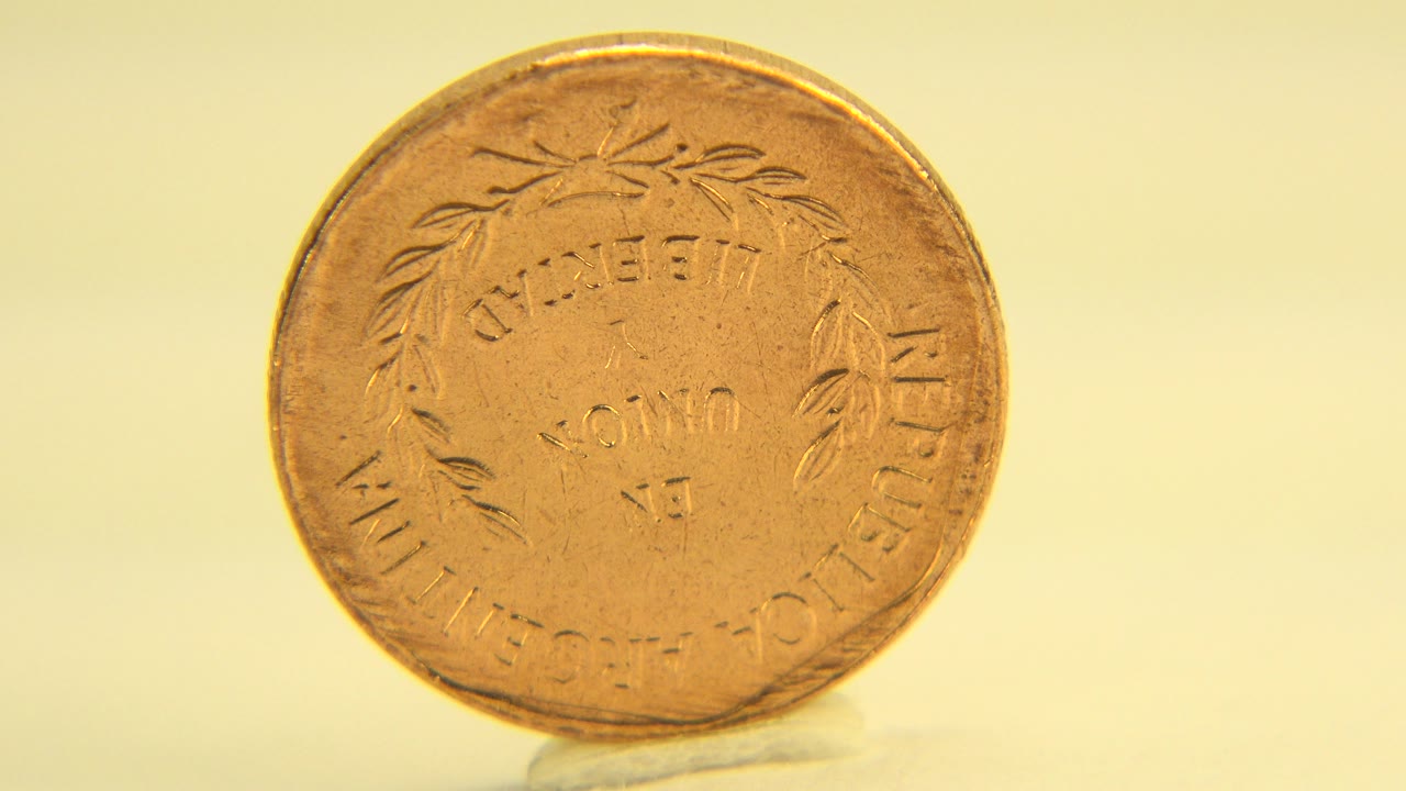 The same upright golden penny remains centered in Westminster, Colorado 2015 footage, with worn circular lettering visible and no visible people.
